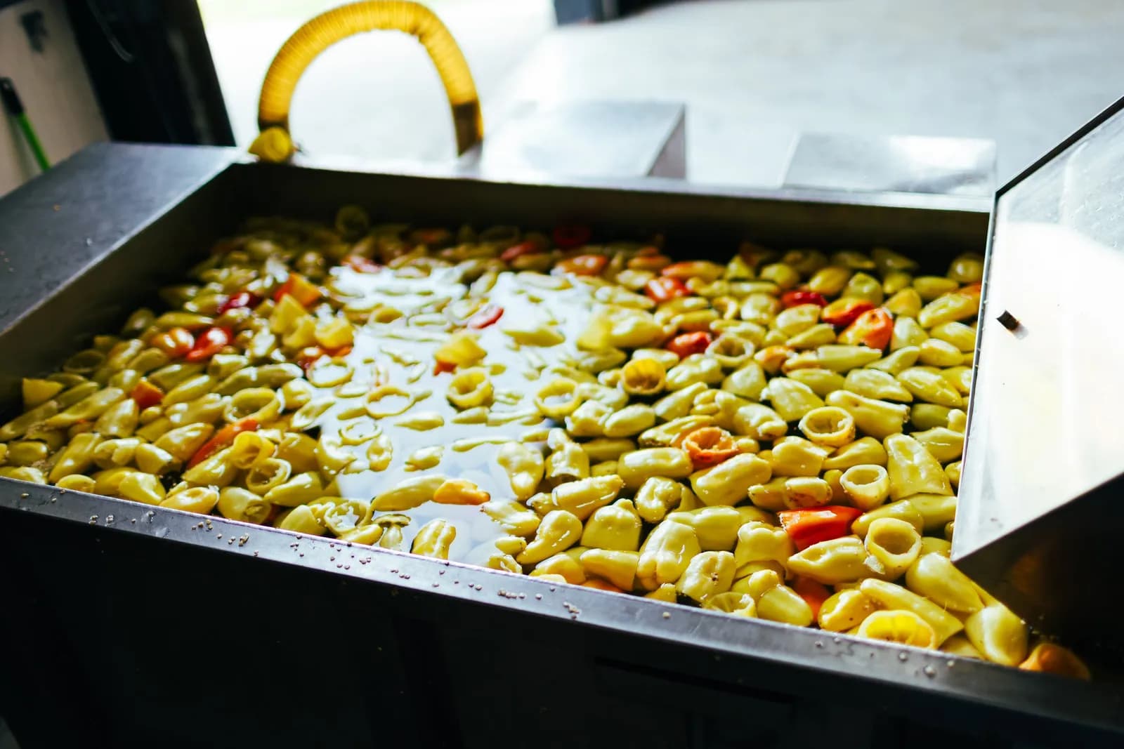 Peppers soaking in a steel washing basin.